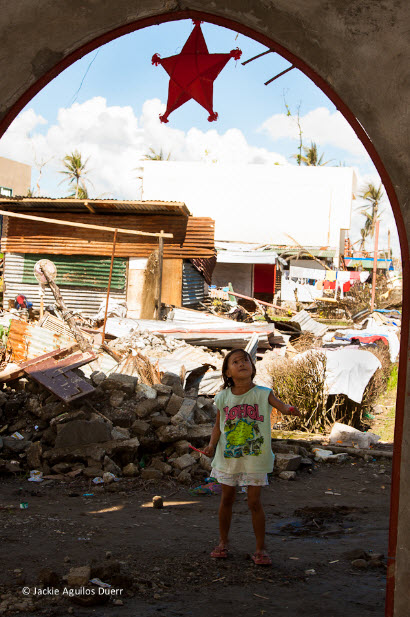 This picture is one of Jackie's, taken in December 2013.  We'll tell the story behind it on the other blog sometime.  I just love that the little girl is focused on the star with a smile on her face, while just behind her is total destruction.